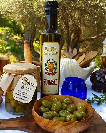 Bottle of Subashi extra virgin Albanian olive oil on a wooden surface